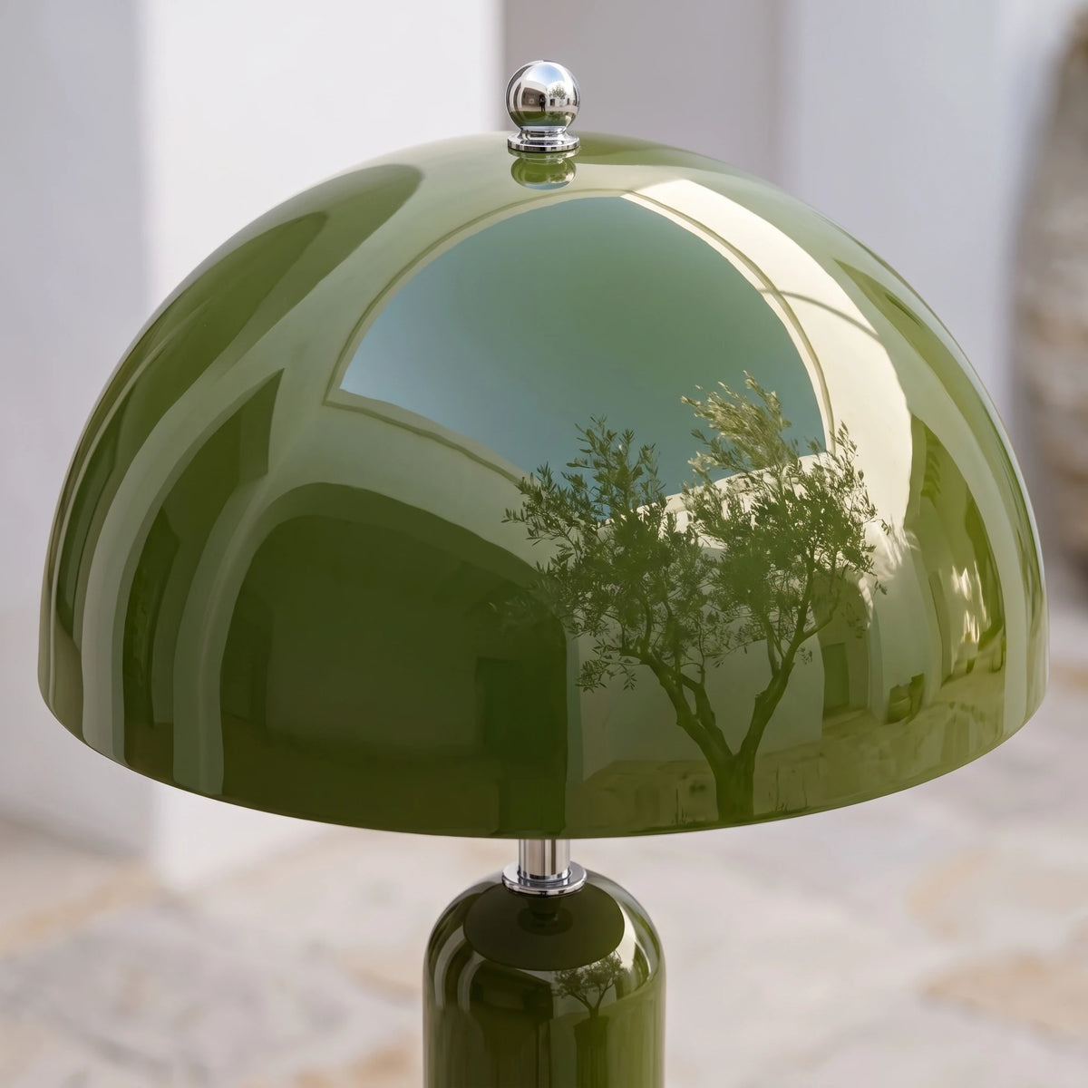 Détail de l'abat-jour dôme vert olive brillant du lampadaire champignon, reflétant un olivier
