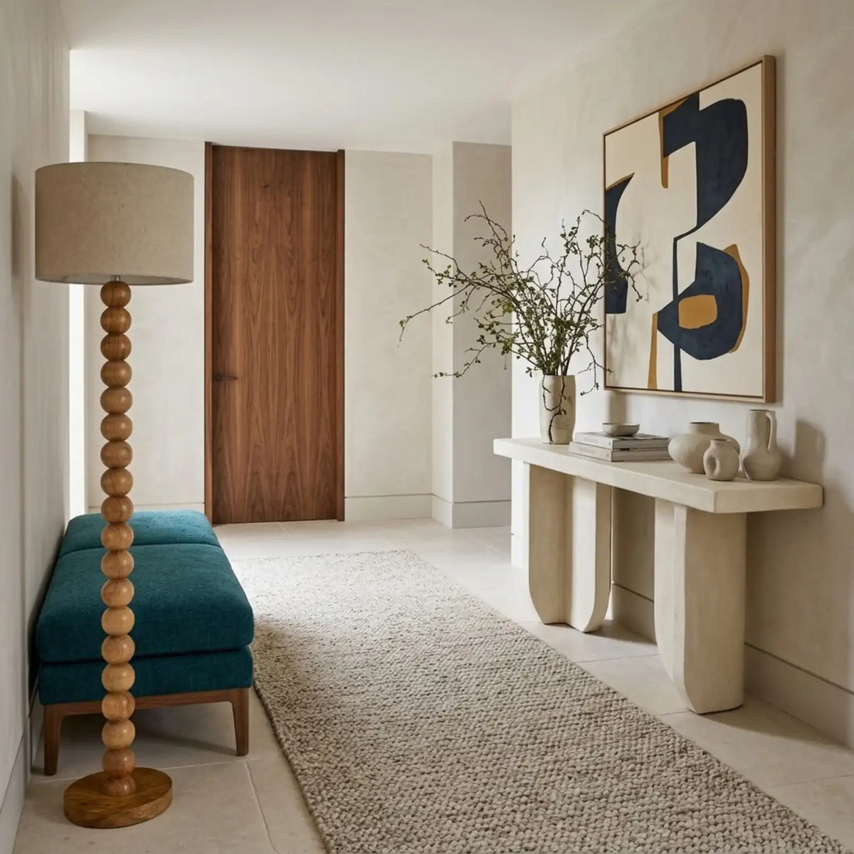 Lampe sur pied à boules en bois dans une entrée, à côté d'une banquette bleu canard et d'une console en pierre claire