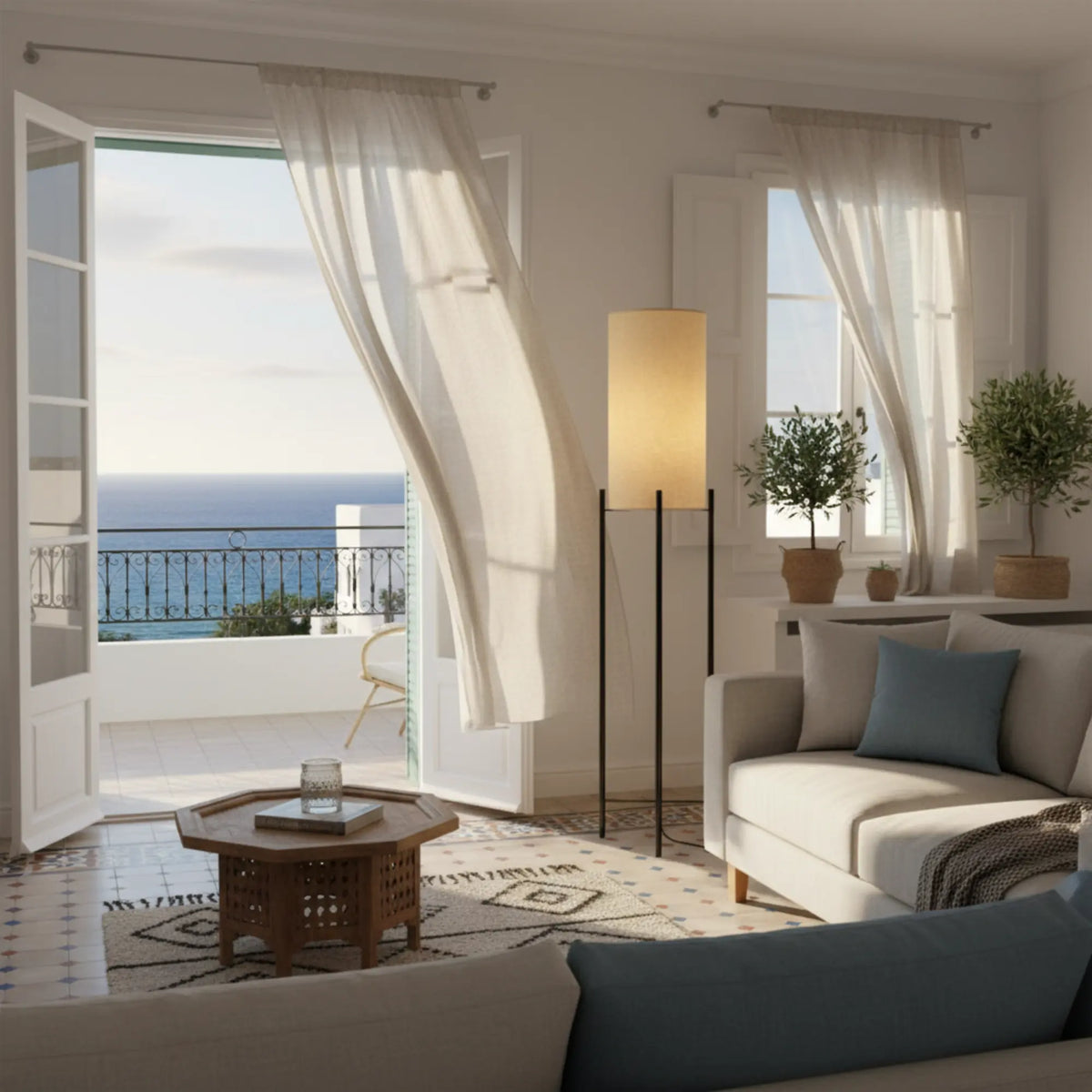 Lampe sur pied en lin et métal noir dans un salon ouvert sur un balcon avec vue sur la mer