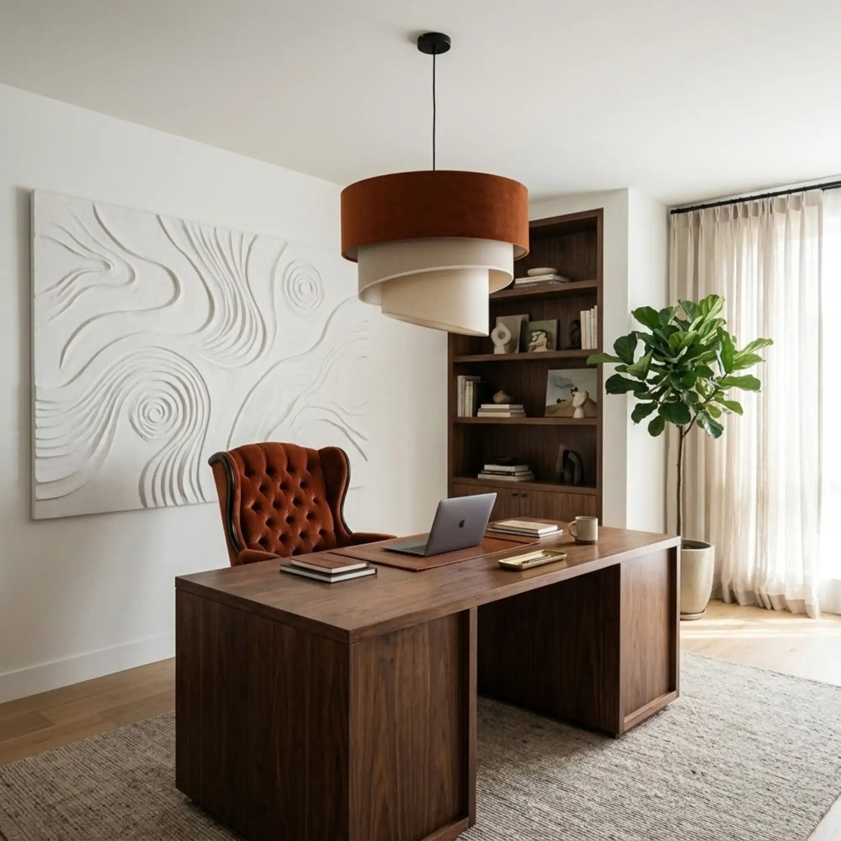 Lustre en velours terracotta au-dessus d'un bureau en noyer, fauteuil capitonné rouille et œuvre en relief