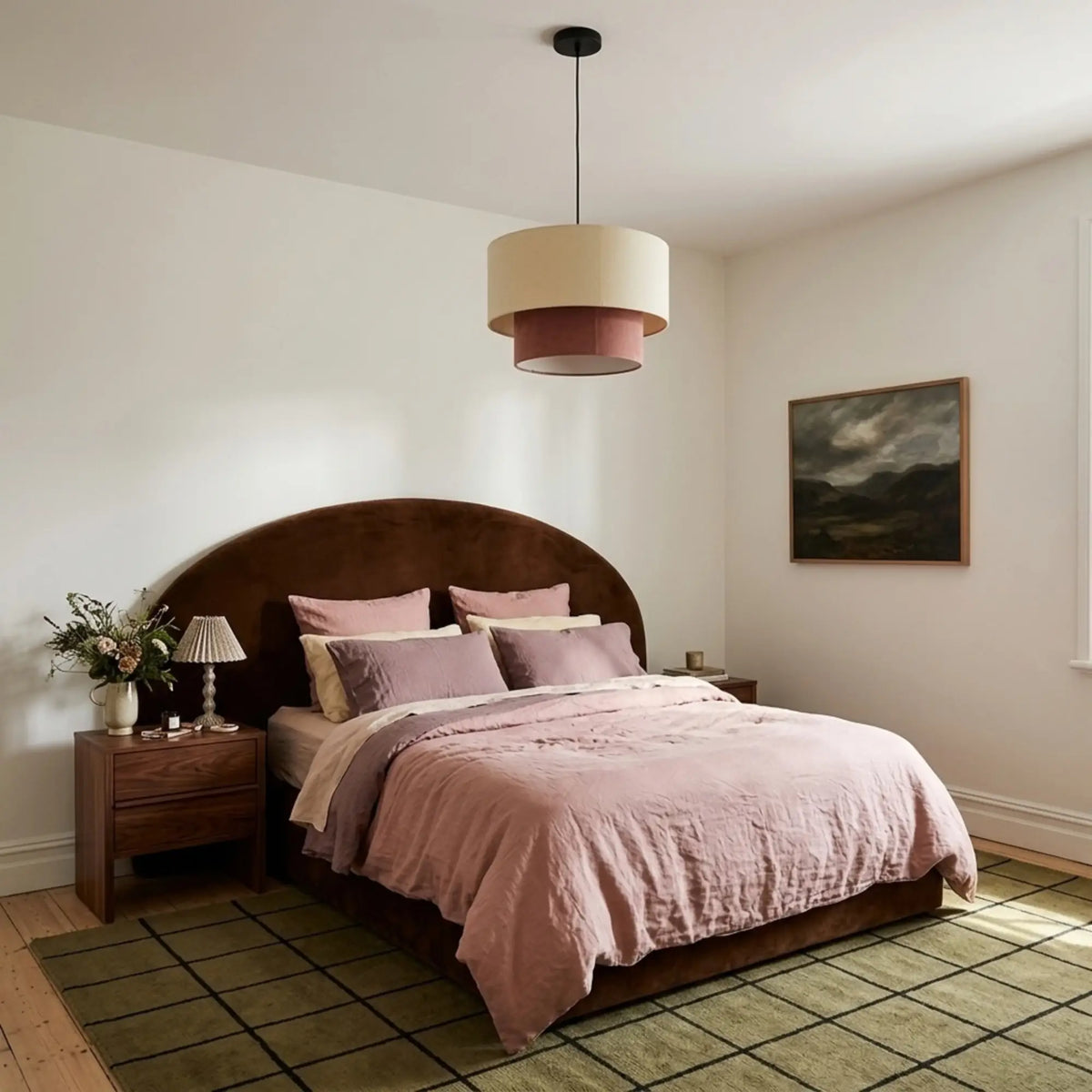 Suspension beige et vieux rose au-dessus d'un lit à tête arrondie en velours marron, tapis vert quadrillé