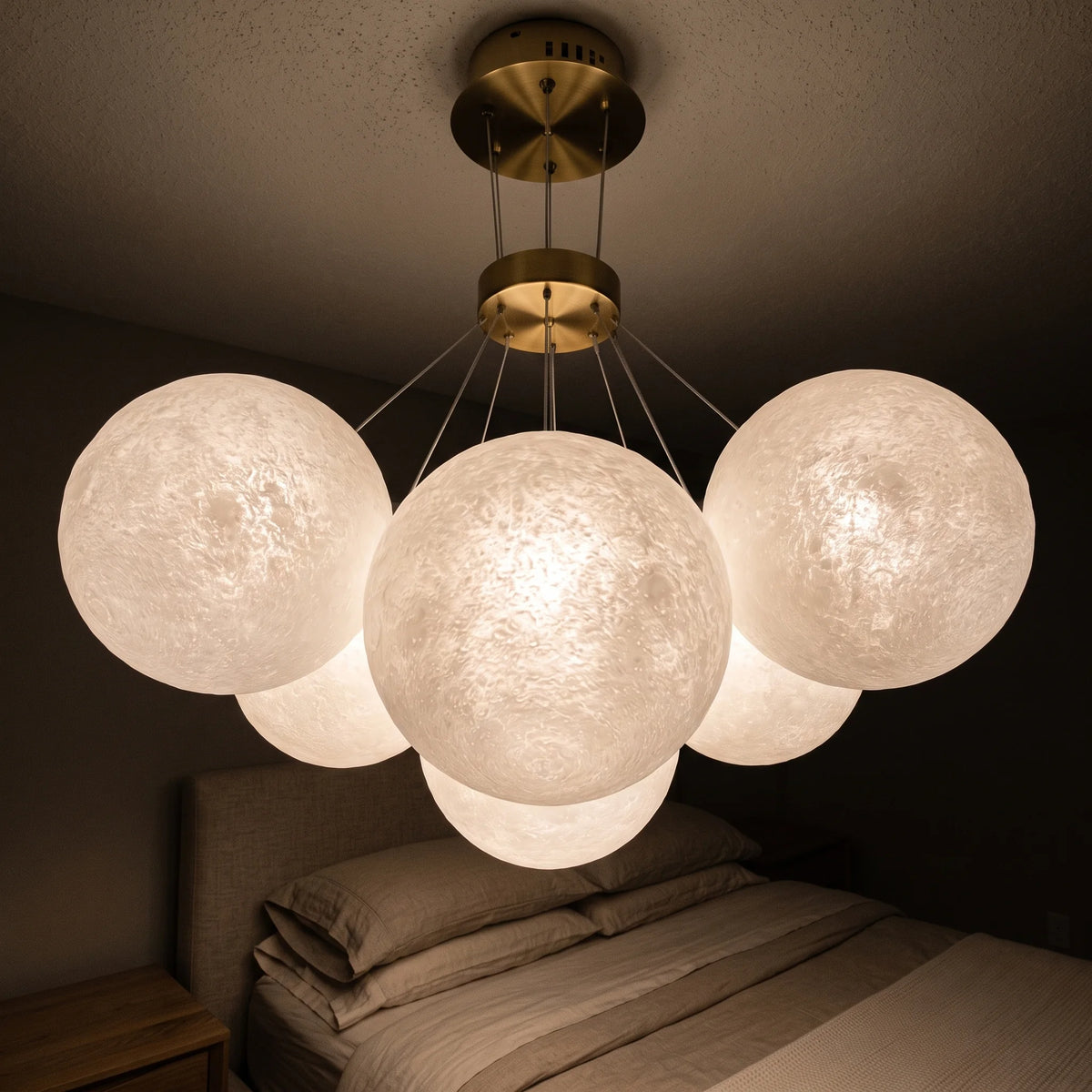 Lustre boules lune suspendu au-dessus d'un lit dans une chambre
