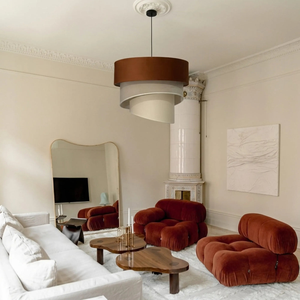 Lustre en velours terracotta suspendu à une rosace, salon aux fauteuils en velours rouille