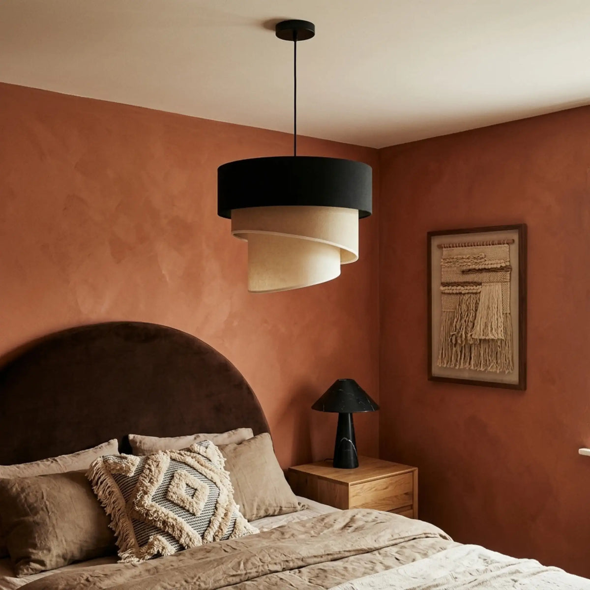 Suspension trois tons dans une chambre aux murs terracotta, tête de lit arrondie en velours marron