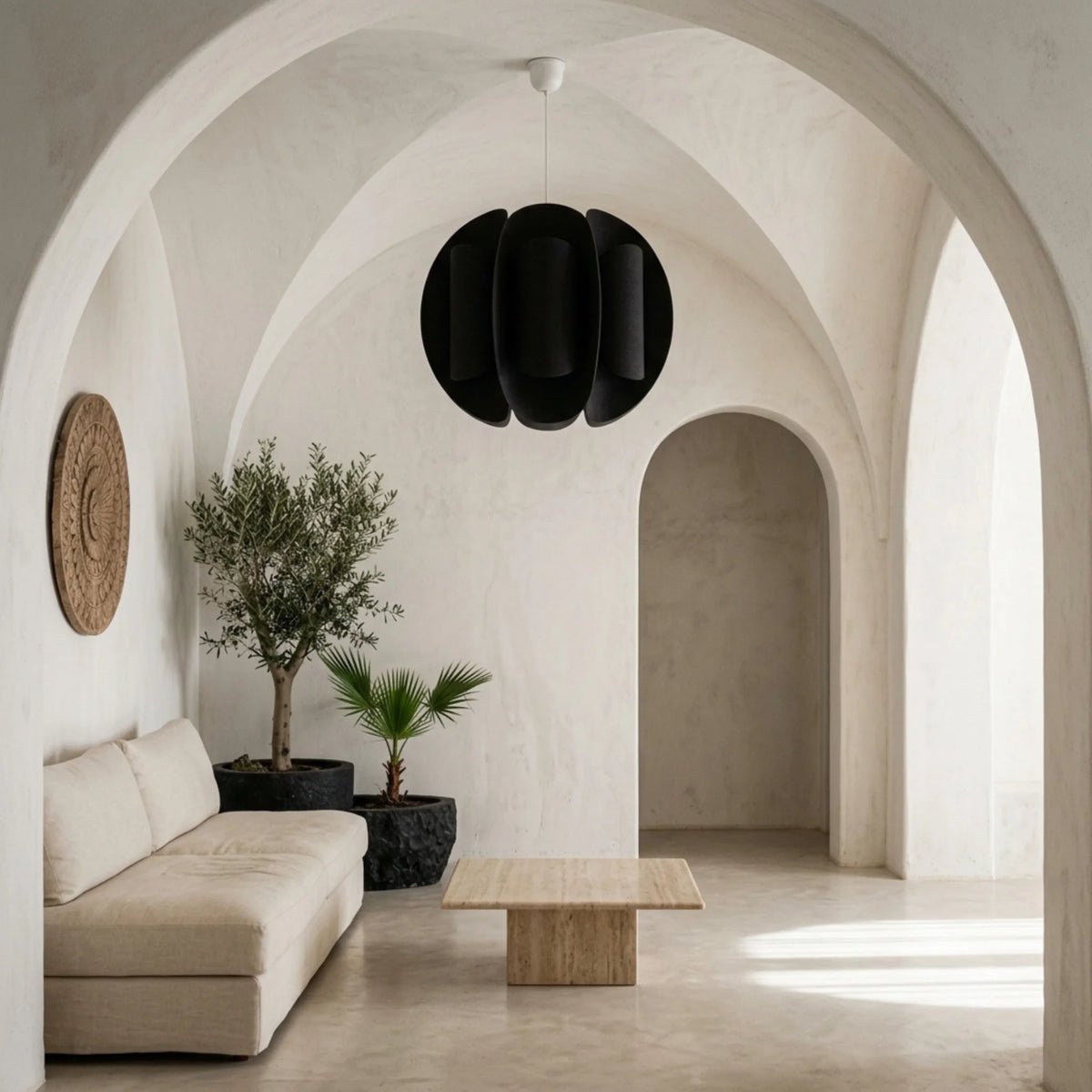 Suspension boule noire dans un couloir méditerranéen voûté avec olivier et table en travertin
