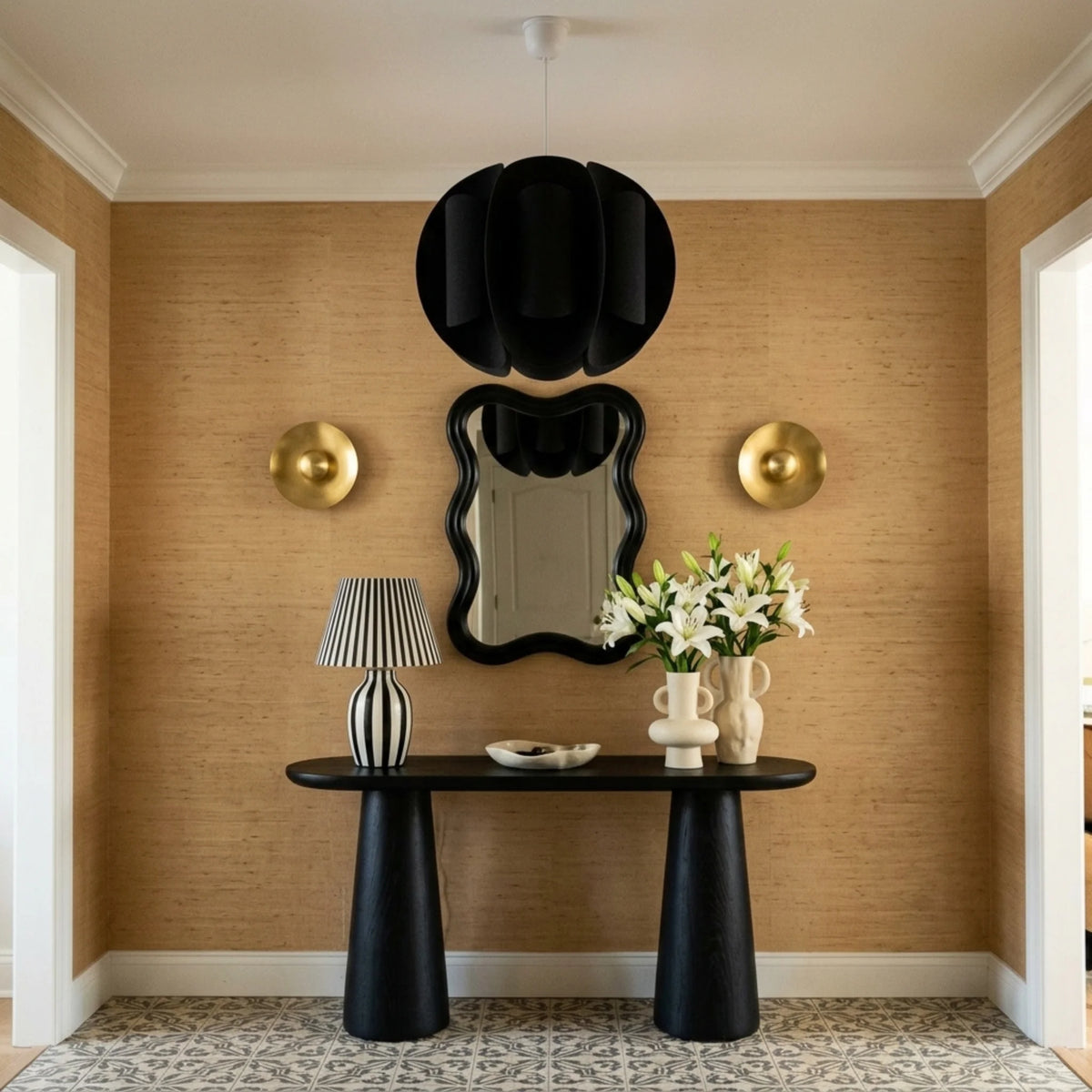 Suspension boule noire dans une entrée avec console noire et miroir ondulé