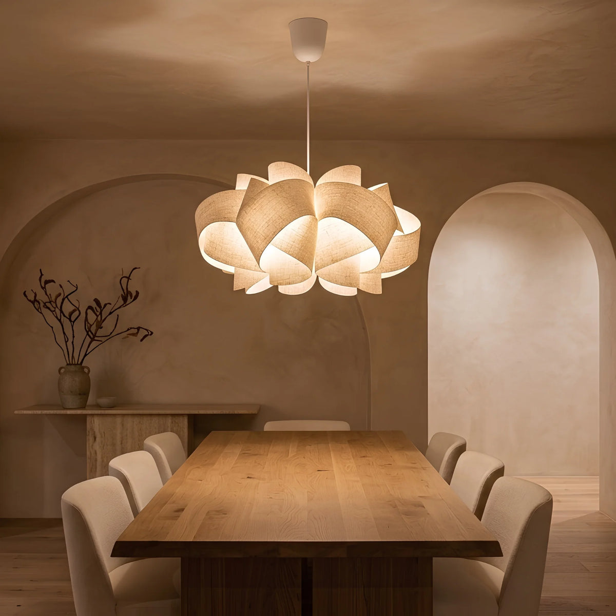 Lustre à pétales en lin au-dessus d'une table de salle à manger sous arche