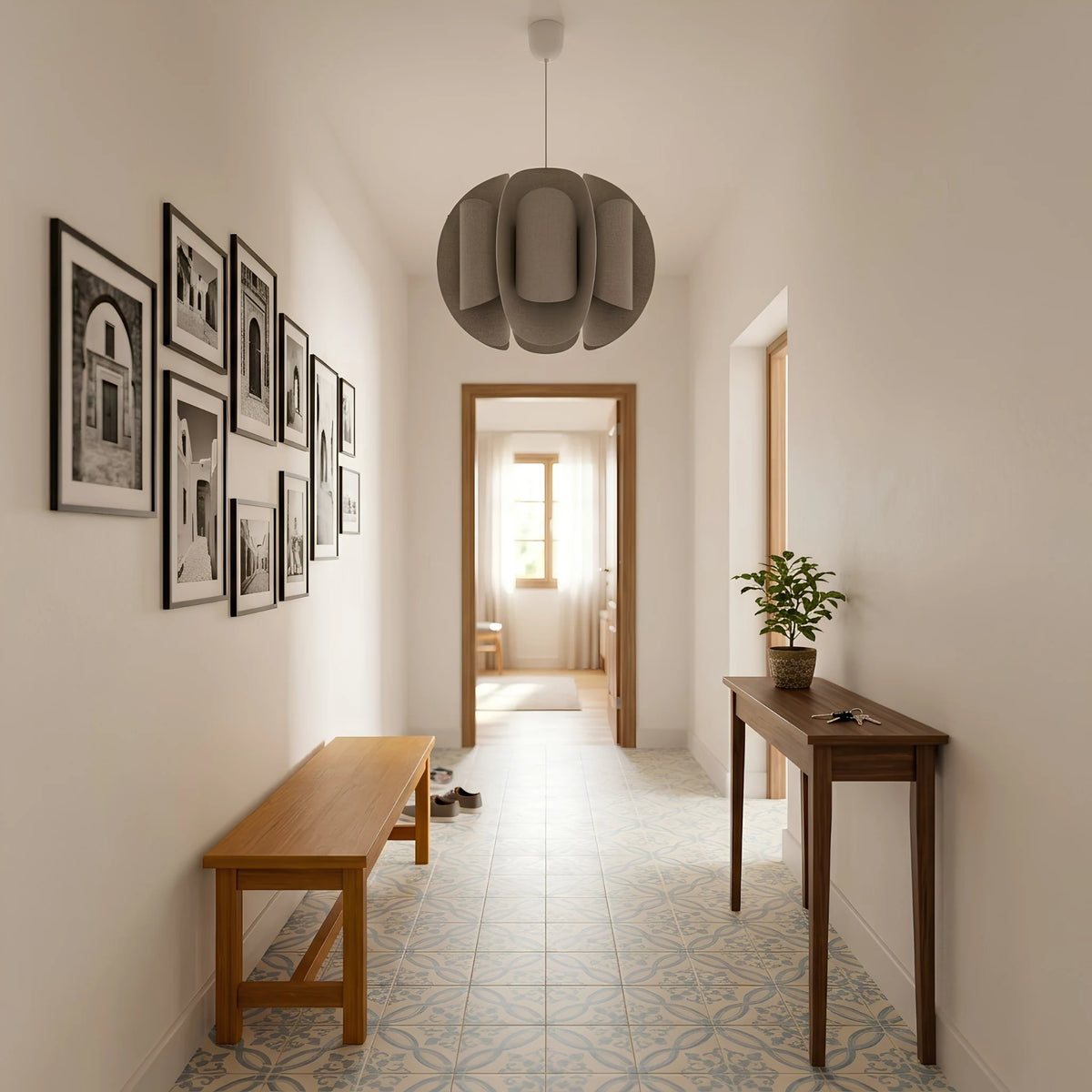 Suspension design taupe dans une entrée avec carreaux de ciment, banc en bois et mur de photos.